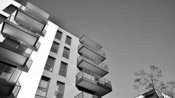 fragmento de el del edificio fachada con ventanas y balcones moderno Departamento edificios en un soleado día. fachada de un moderno residencial edificio. negro y blanco. foto