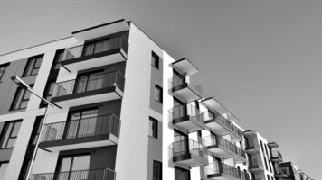 Fragment of the building's facade with windows and balconies. Modern apartment buildings on a sunny day. Facade of a modern residential building. Black and white. photo