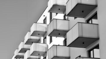 fragmento de el del edificio fachada con ventanas y balcones moderno Departamento edificios en un soleado día. fachada de un moderno residencial edificio. negro y blanco. foto