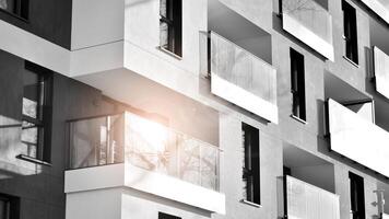 fragmento de un fachada de un edificio con ventanas y balcones moderno Departamento edificios en un soleado día. fachada de un moderno Departamento edificio. negro y blanco. foto