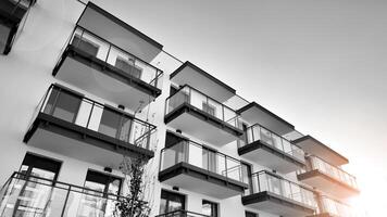 fragmento de un fachada de un edificio con ventanas y balcones moderno Departamento edificios en un soleado día. fachada de un moderno Departamento edificio. negro y blanco. foto