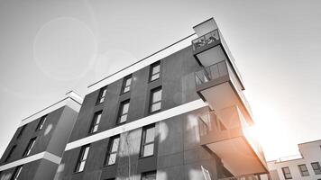 Fragment of a facade of a building with windows and balconies. Modern apartment buildings on a sunny day. Facade of a modern apartment building. Black and white. photo