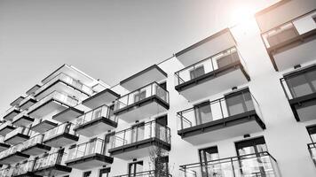 Fragment of a facade of a building with windows and balconies. Modern apartment buildings on a sunny day. Facade of a modern apartment building. Black and white. photo