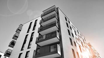 fragmento de un fachada de un edificio con ventanas y balcones moderno Departamento edificios en un soleado día. fachada de un moderno Departamento edificio. negro y blanco. foto