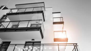 Fragment of a facade of a building with windows and balconies. Modern apartment buildings on a sunny day. Facade of a modern apartment building. Black and white. photo