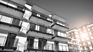 Fragment of a facade of a building with windows and balconies. Modern apartment buildings on a sunny day. Facade of a modern apartment building. Black and white. photo