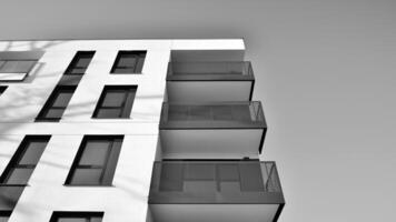 Fragment of a facade of a building with windows and balconies. Modern apartment buildings on a sunny day. Facade of a modern apartment building. Black and white. photo