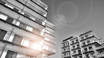 Fragment of a facade of a building with windows and balconies. Modern apartment buildings on a sunny day. Facade of a modern apartment building. Black and white. photo