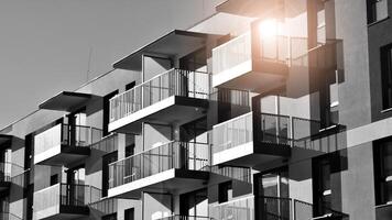 fragmento de un fachada de un edificio con ventanas y balcones moderno Departamento edificios en un soleado día. fachada de un moderno Departamento edificio. negro y blanco. foto