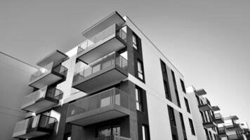 Fragment of a facade of a building with windows and balconies. Modern apartment buildings on a sunny day. Facade of a modern apartment building. Black and white. photo