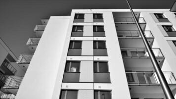 fragmento de un fachada de un edificio con ventanas y balcones moderno Departamento edificios en un soleado día. fachada de un moderno Departamento edificio. negro y blanco. foto