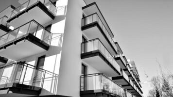 Fragment of a facade of a building with windows and balconies. Modern apartment buildings on a sunny day. Facade of a modern apartment building. Black and white. photo