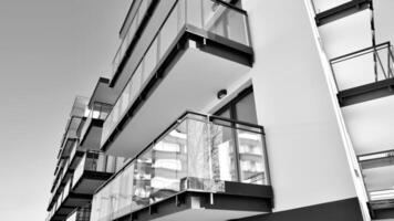 Fragment of a facade of a building with windows and balconies. Modern apartment buildings on a sunny day. Facade of a modern apartment building. Black and white. photo