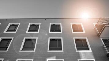 fragmento de un fachada de un edificio con ventanas y balcones moderno Departamento edificios en un soleado día. fachada de un moderno Departamento edificio. negro y blanco. foto