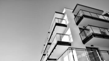 fragmento de un fachada de un edificio con ventanas y balcones moderno Departamento edificios en un soleado día. fachada de un moderno Departamento edificio. negro y blanco. foto