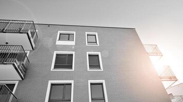 fragmento de un fachada de un edificio con ventanas y balcones moderno Departamento edificios en un soleado día. fachada de un moderno Departamento edificio. negro y blanco. foto