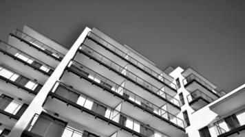 Fragment of a facade of a building with windows and balconies. Modern apartment buildings on a sunny day. Facade of a modern apartment building. Black and white. photo