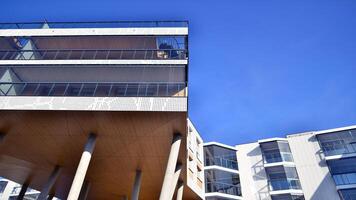 un Departamento edificio con un único arquitectónico solución. un moderno residencial edificio con un blanco fachada y en pie en alto hormigón pilares foto