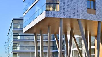 un Departamento edificio con un único arquitectónico solución. un moderno residencial edificio con un blanco fachada y en pie en alto hormigón pilares foto