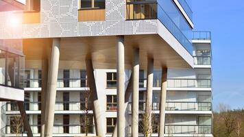 un Departamento edificio con un único arquitectónico solución. un moderno residencial edificio con un blanco fachada y en pie en alto hormigón pilares foto