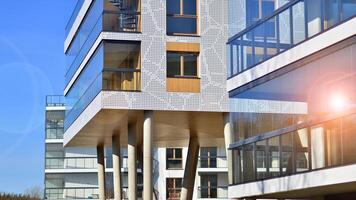 A apartment building with a unique architectural solution. A modern residential building with a white facade and standing on high concrete pillars. photo