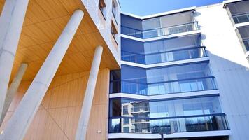 un Departamento edificio con un único arquitectónico solución. un moderno residencial edificio con un blanco fachada y en pie en alto hormigón pilares foto