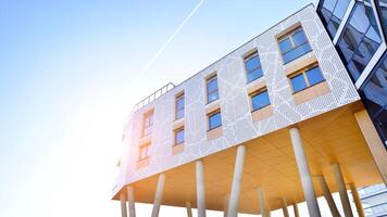 A apartment building with a unique architectural solution. A modern residential building with a white facade and standing on high concrete pillars. photo