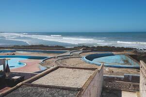 Abandoned swimming pool on the rooftop in Casablanca city, Atlantic beach on the background photo