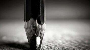 a close up of a pencil on a table black and white photo