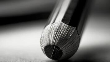 a close up of a pencil on a table black and white photo