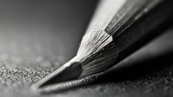 a close up of a pencil on a table black and white photo