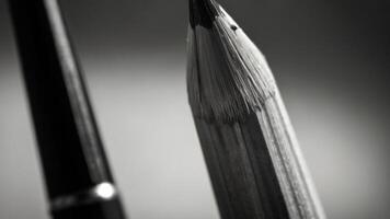 a close up of a pencil on a table black and white photo