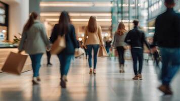 Defocused people walking in a modern shopping mall with some shoppers in motion blur photo