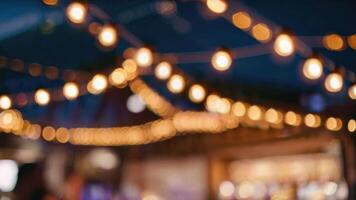 desenfocado restaurante con al aire libre cuerda luces en un borroso antecedentes foto