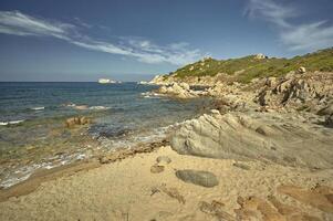 The rocks of the Mediterranean beach at sunset. photo