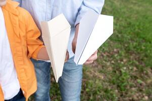 Paper planes in the hands of a man and a child photo