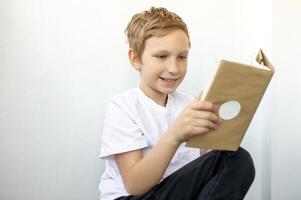 The cute boy is passionate about reading a book. Read an interesting book. School education photo