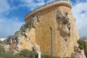 Stone watchtower on a cliff with clear sky. Historical architecture photography. photo