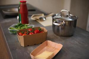 Healthy fresh organic ingredients and a stainless steel pan on the kitchen countertop. Healthy ingredients for Mediterranean lunch photo