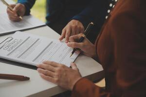 Lawyer, legal advisor, businessman brainstorming information on agreement details Business contracts in legal processing books for accuracy in contract documents. joint financial investment. photo