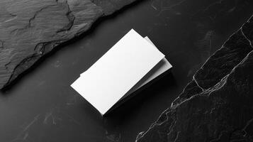 Blank white business card mockup on black stone. Modern minimalist template. Branding identity. Natural Flat lay, top view photo