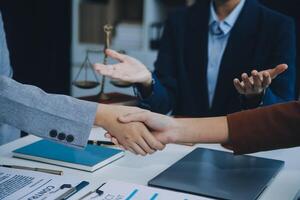 Businessman shaking hands to seal a deal with his partner lawyers or attorneys discussing a contract agreement. photo