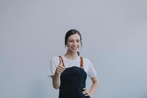 Cheerful beautiful Asian woman wearing jeans overalls with excited doing winner gesture with arms raised isolated on white background. photo