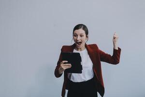 Photo of young attractive happy positive woman hold pc tablet hand touch chin isolated over grey color background