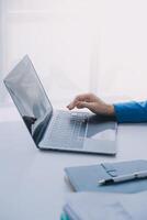 Cheerful business lady working on laptop in office, Asian happy beautiful businesswoman in formal suit work in workplace. Attractive female employee office worker smile. photo