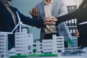 Two business executives, elegantly attired in suits, join hands in a gesture of unity, solidarity, and shared commitment towards a common goal or venture. photo