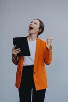 Smiling caucasian young woman girl freelancer student using digital tablet, having idea, pointing upwards on copyspace, surfing on social media, mobile applications, e-learning isolated in white photo