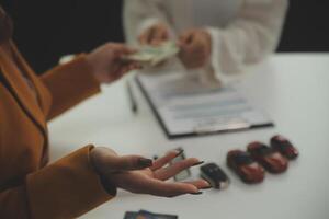 Insurance officers hand over the car keys after the tenant. have signed an auto insurance document or a lease or agreement document Buying or selling a new or used car with a car photo