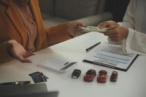 Insurance officers hand over the car keys after the tenant. have signed an auto insurance document or a lease or agreement document Buying or selling a new or used car with a car photo