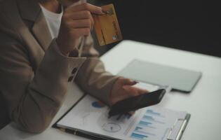 Close up smiling millennial woman holding smartphone and banking credit card, involved in online mobile shopping at home, happy female shopper purchasing goods or services in internet store. photo